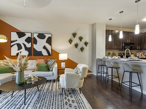 a living room with a couch and a table in front of a kitchen
